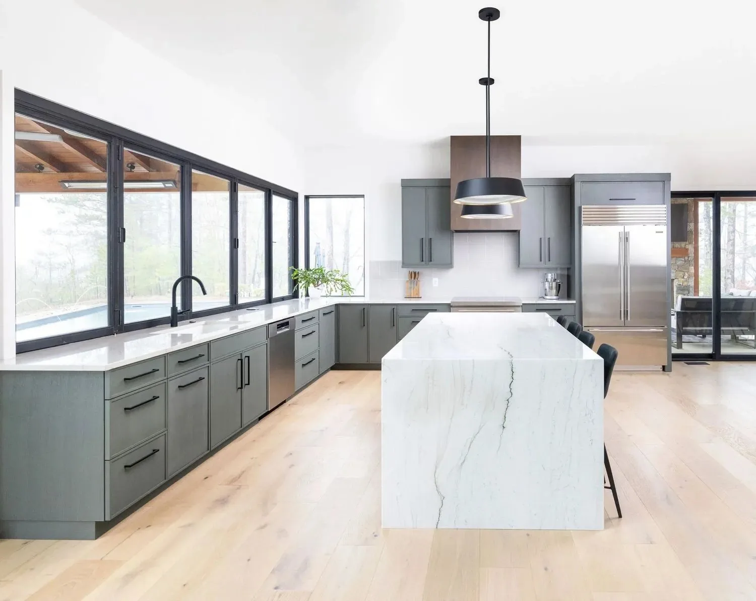 A Forest Kitchen Design kitchen with a marble island and green cabinetry